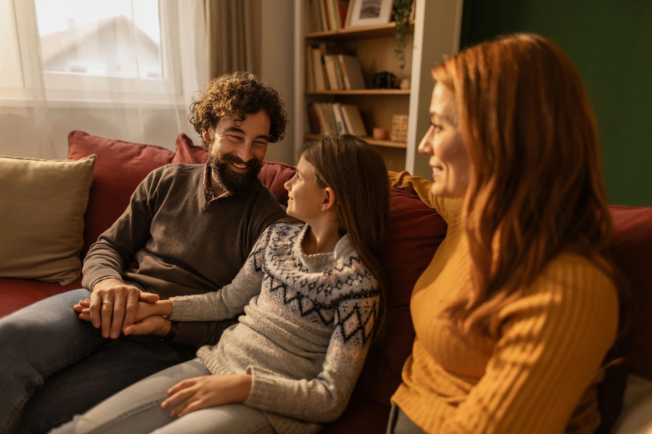 Family relaxing on a sofa at home communicating